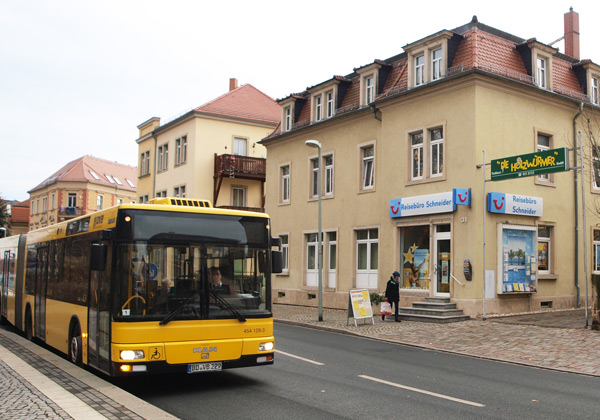 Außenansicht des Reisebüros Schneider mit einem Linienbus vor dem Gebäude
